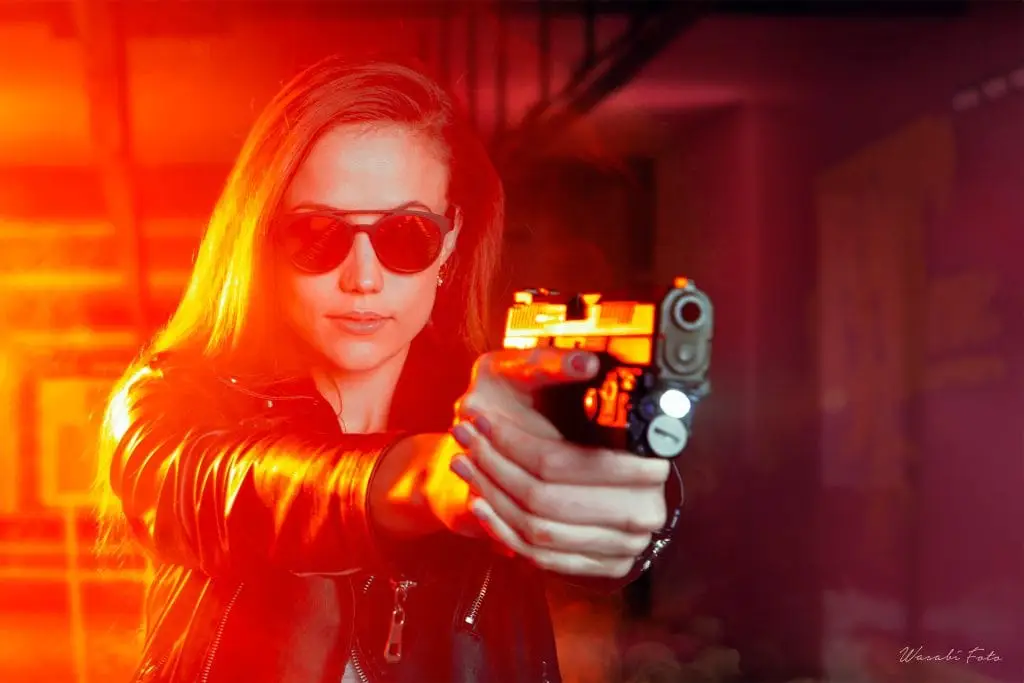 A beautiful blonde lady training withe her gun at an indoor shooting range