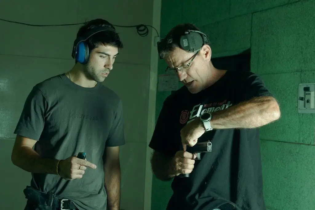 A Shooting Instructor showing trigger finger position to a new student