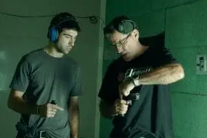 A Shooting Instructor showing trigger finger position to a new student