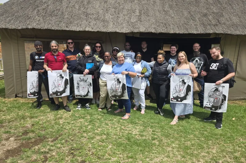 A group of participants proudly holding their shooting targets after completing a firearm training session at The Shooting Range.